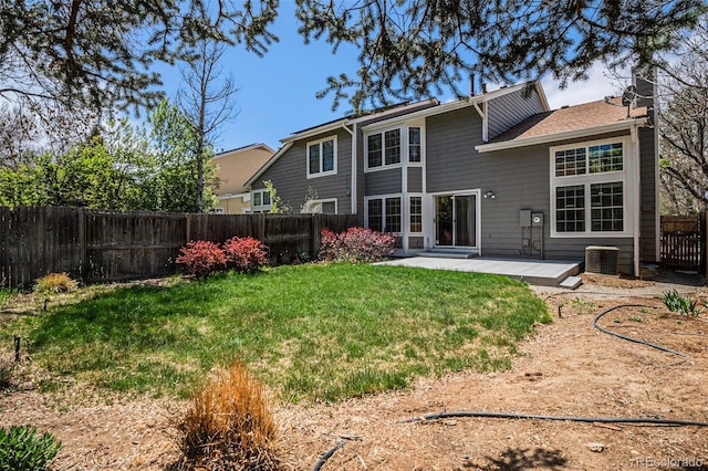 rear view of house featuring a yard, a patio, central AC unit, and a fenced backyard