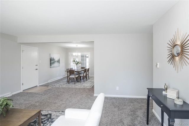 carpeted living room featuring a notable chandelier