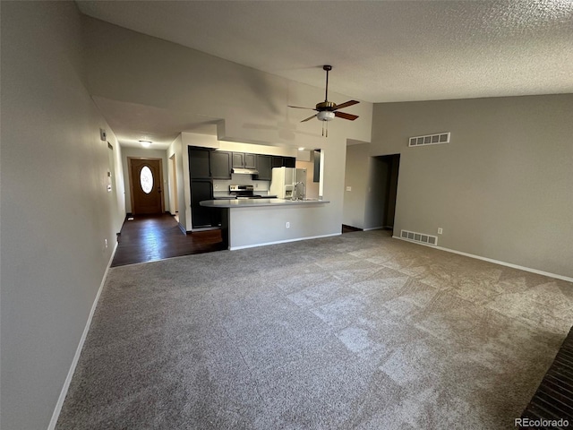 unfurnished living room with ceiling fan, dark carpet, a textured ceiling, and high vaulted ceiling