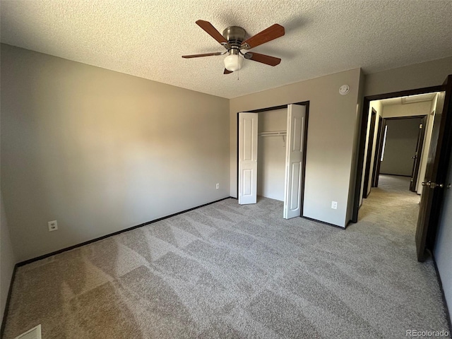 unfurnished bedroom with ceiling fan, a closet, light carpet, and a textured ceiling