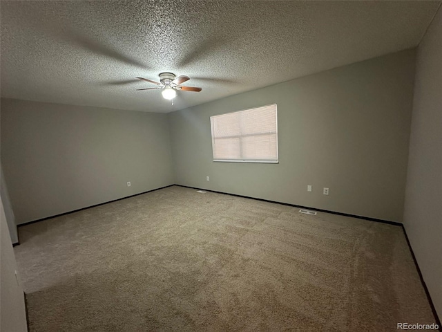 empty room with ceiling fan, light colored carpet, and a textured ceiling