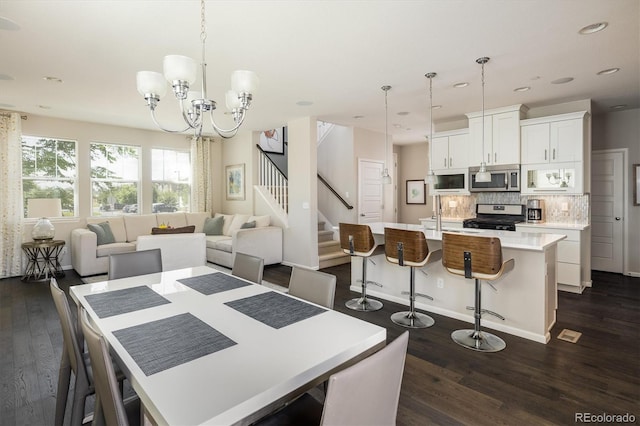 5451 W 73rd Ave, Westminster, CO 80003 - dining space with dark wood-style floors, a chandelier, recessed lighting, and stairway