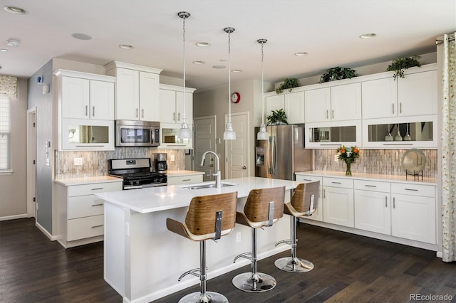 5451 W 73rd Ave, Westminster, CO 80003 - kitchen with appliances with stainless steel finishes, decorative backsplash, dark wood-type flooring, a center island with sink, and recessed lighting