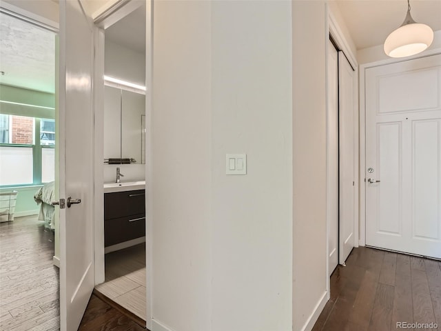 hallway with dark wood-type flooring and sink