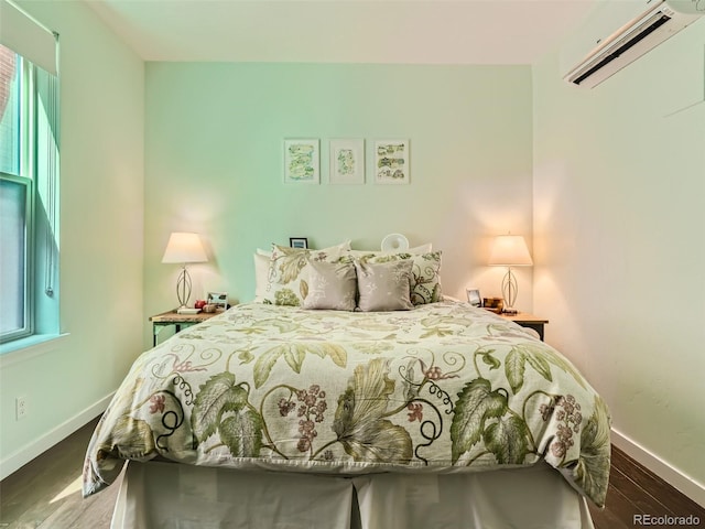 bedroom with wood-type flooring and an AC wall unit