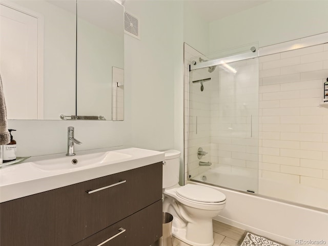 full bathroom featuring enclosed tub / shower combo, vanity, and toilet