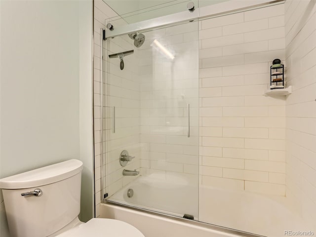 bathroom with toilet and combined bath / shower with glass door