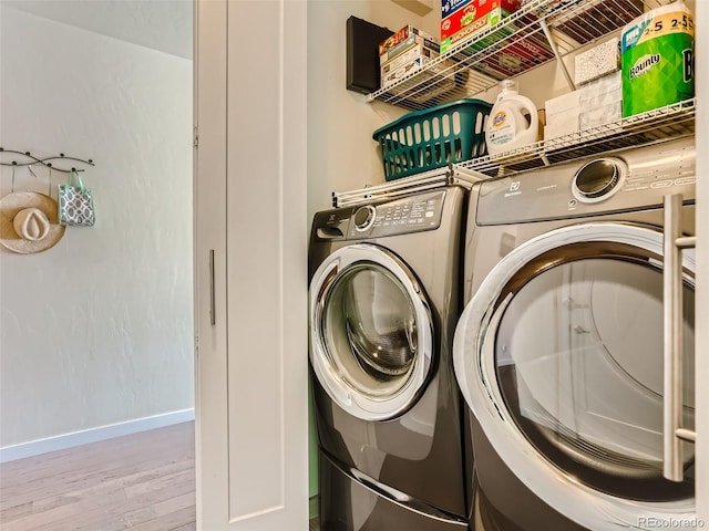 laundry room featuring washer and dryer and light hardwood / wood-style floors