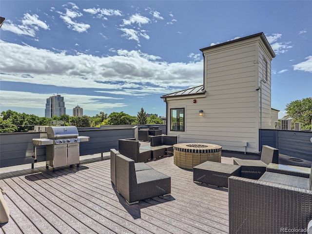 deck with area for grilling and an outdoor living space with a fire pit