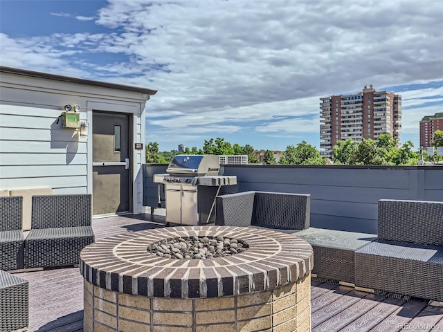 wooden deck with grilling area and a fire pit