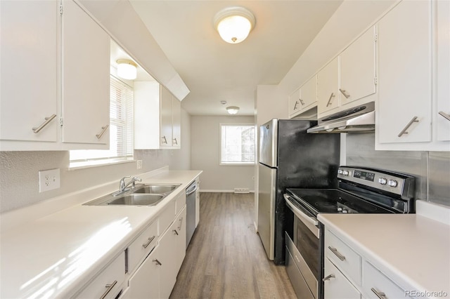 kitchen featuring hardwood / wood-style flooring, sink, white cabinets, and appliances with stainless steel finishes