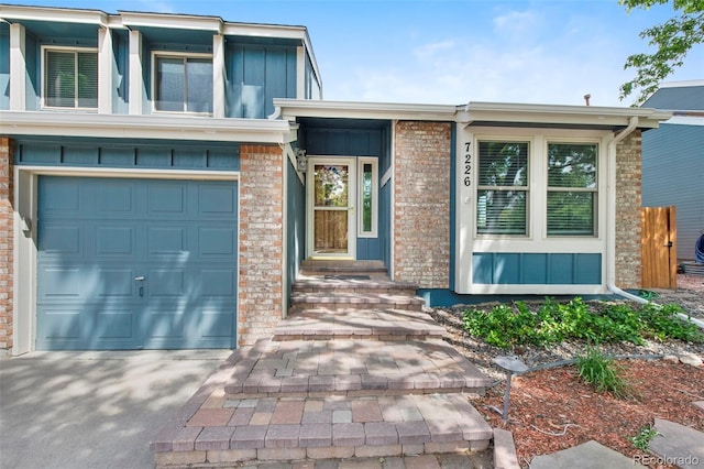 7226 S Eagles Nest Cir, Littleton, CO 80127 - view of front facade featuring board and batten siding, an attached garage, driveway, and brick siding