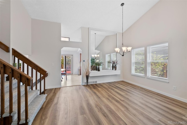 7226 S Eagles Nest Cir, Littleton, CO 80127 - entrance foyer featuring a chandelier, a high ceiling, arched walkways, wood finished floors, and baseboards