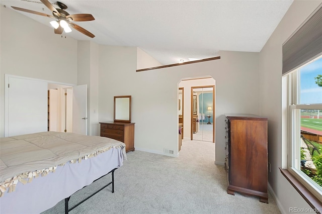 7226 S Eagles Nest Cir, Littleton, CO 80127 - bedroom featuring arched walkways, multiple windows, light carpet, vaulted ceiling, and baseboards