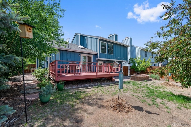 7226 S Eagles Nest Cir, Littleton, CO 80127 - rear view of house with a wooden deck, a fenced backyard, board and batten siding, and a chimney