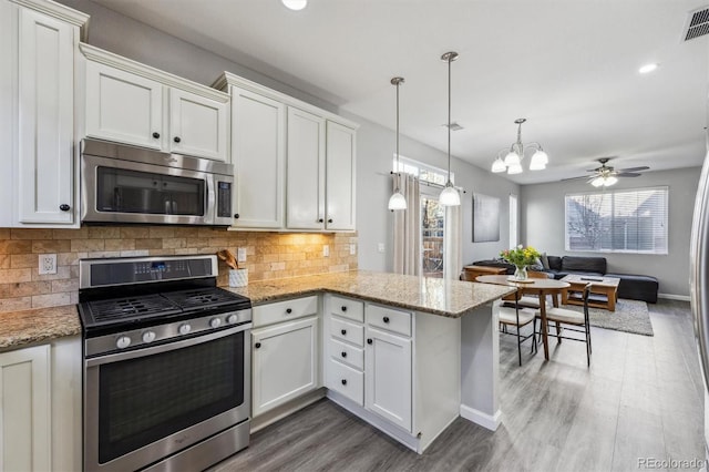 kitchen featuring stainless steel appliances, plenty of natural light, backsplash, and open floor plan