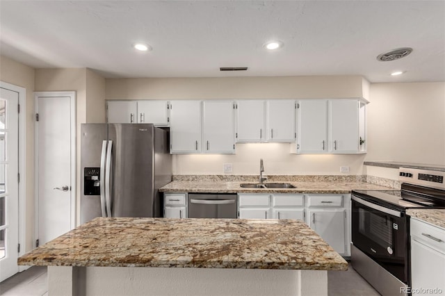 2301 E Fremont Ave Unit W08, Centennial, CO 80122 - kitchen with appliances with stainless steel finishes, white cabinets, light stone countertops, a kitchen island, and recessed lighting