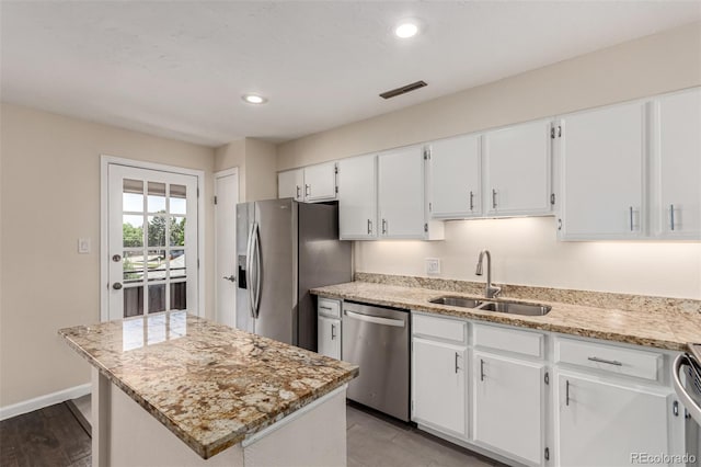 2301 E Fremont Ave Unit W08, Centennial, CO 80122 - kitchen featuring stainless steel appliances, white cabinets, light stone counters, a kitchen island, and recessed lighting