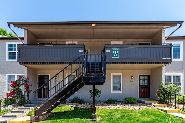 2301 E Fremont Ave Unit W08, Centennial, CO 80122 - view of front of house featuring stairs, stucco siding, and a front yard