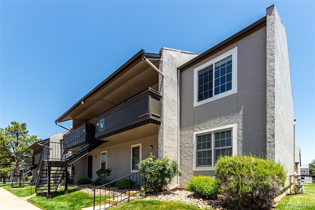 2301 E Fremont Ave Unit W08, Centennial, CO 80122 - view of side of home featuring stairs, stucco siding, and a balcony