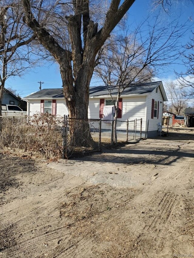 exterior space featuring a fenced front yard and dirt driveway