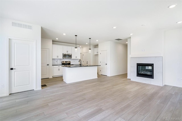 9360 Bahama Ct, Commerce City, CO 80022 - kitchen with dark countertops, appliances with stainless steel finishes, open floor plan, recessed lighting, and light wood-style floors