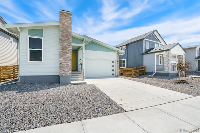 9360 Bahama Ct, Commerce City, CO 80022 - view of front facade featuring driveway, a chimney, and an attached garage