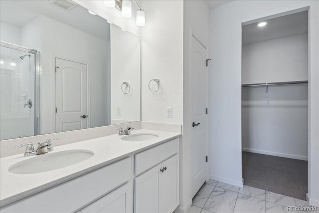 bathroom with a shower with shower door and vanity