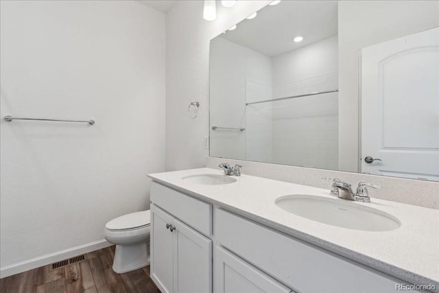 bathroom featuring toilet, vanity, and hardwood / wood-style floors