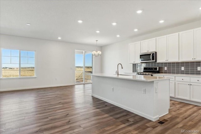 kitchen with pendant lighting, sink, white cabinetry, a kitchen island with sink, and stainless steel appliances