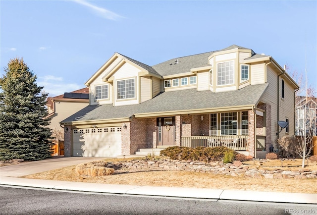 traditional home featuring driveway, roof with shingles, an attached garage, covered porch, and brick siding