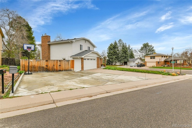 7796 S Marshall Ct, Littleton, CO 80128 - view of front facade featuring fence, driveway, a garage, a chimney, and brick siding
