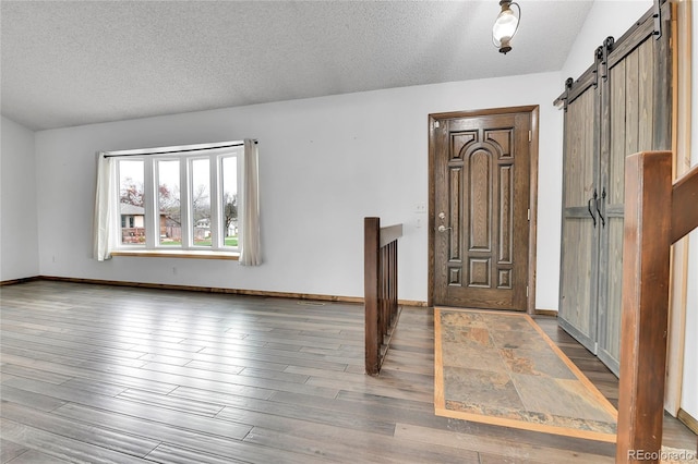 7796 S Marshall Ct, Littleton, CO 80128 - entrance foyer with a barn door, a textured ceiling, and wood finished floors