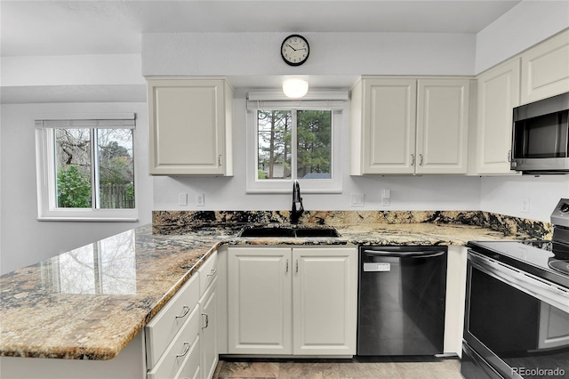 7796 S Marshall Ct, Littleton, CO 80128 - kitchen with appliances with stainless steel finishes, white cabinetry, a peninsula, and light stone counters