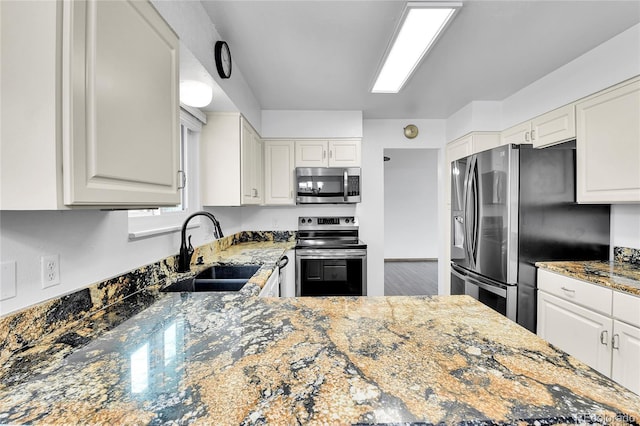 7796 S Marshall Ct, Littleton, CO 80128 - kitchen with stainless steel appliances, stone counters, and white cabinets