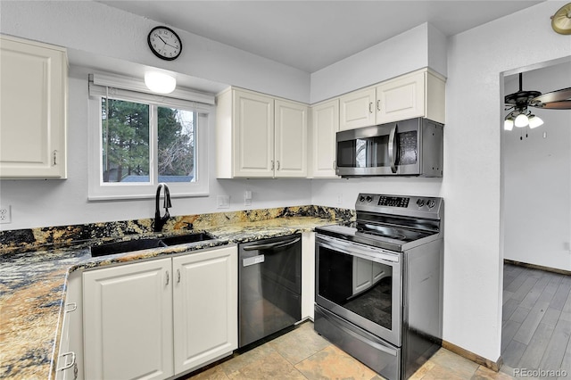 7796 S Marshall Ct, Littleton, CO 80128 - kitchen featuring stainless steel appliances, light stone counters, white cabinets, and ceiling fan