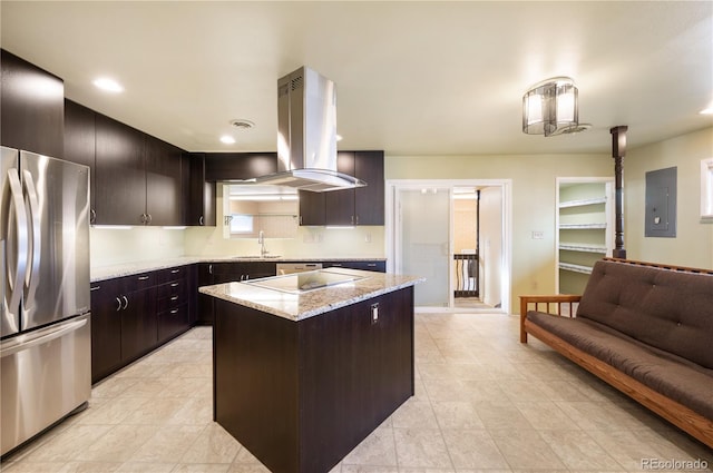 kitchen featuring stainless steel refrigerator, sink, cooktop, electric panel, and a kitchen island