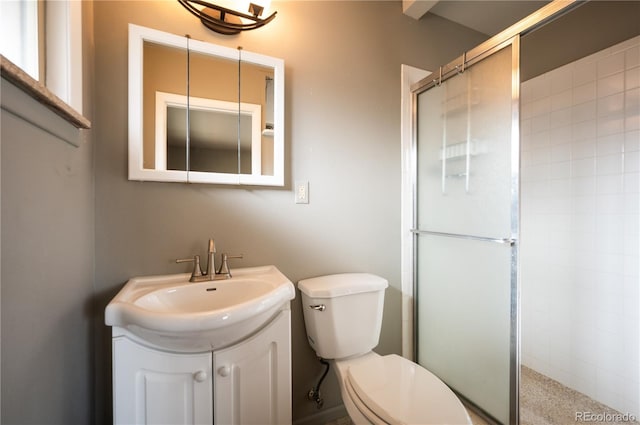 bathroom featuring vanity, toilet, and a shower with shower door