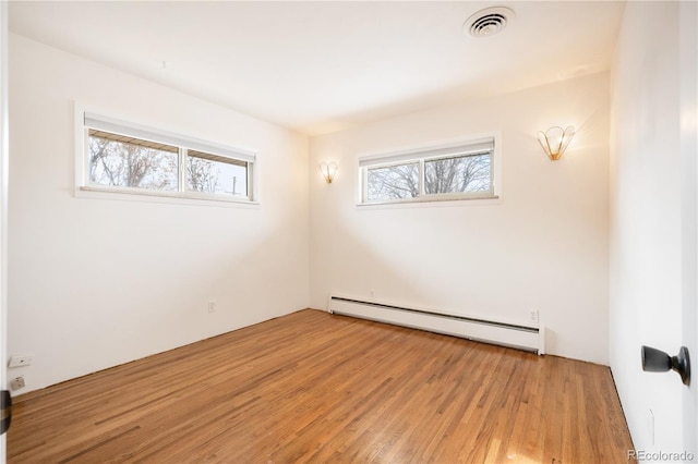 spare room featuring light hardwood / wood-style floors, plenty of natural light, and baseboard heating