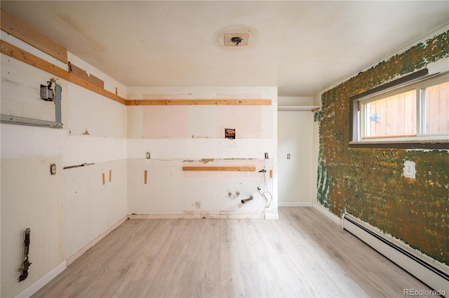 spare room with a baseboard radiator and light wood-type flooring