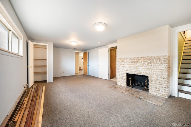 unfurnished living room featuring a fireplace and carpet