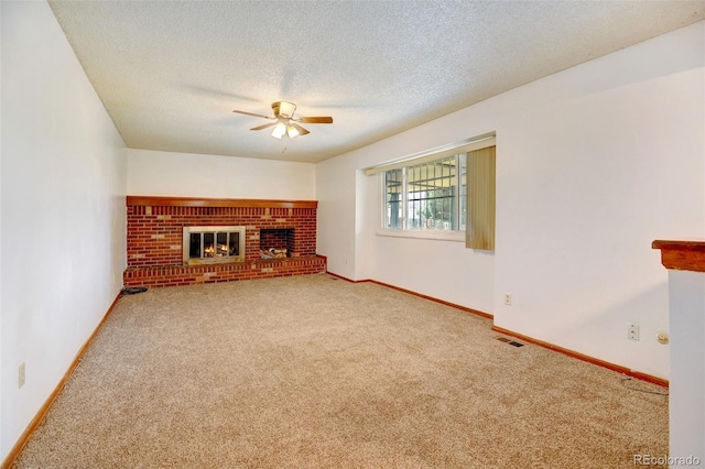 1487 S Zeno Way, Aurora, CO 80017 - unfurnished living room featuring a ceiling fan, carpet floors, a fireplace, baseboards, and a textured ceiling