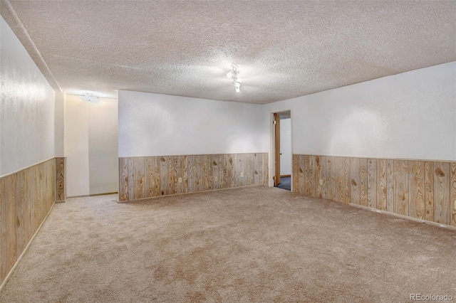 1487 S Zeno Way, Aurora, CO 80017 - unfurnished room with wooden walls, a wainscoted wall, carpet flooring, and a textured ceiling