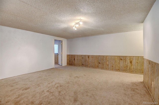 1487 S Zeno Way, Aurora, CO 80017 - unfurnished room with wood walls, carpet flooring, wainscoting, and a textured ceiling
