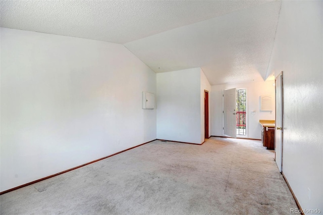 1487 S Zeno Way, Aurora, CO 80017 - spare room featuring light colored carpet, electric panel, lofted ceiling, baseboards, and a textured ceiling