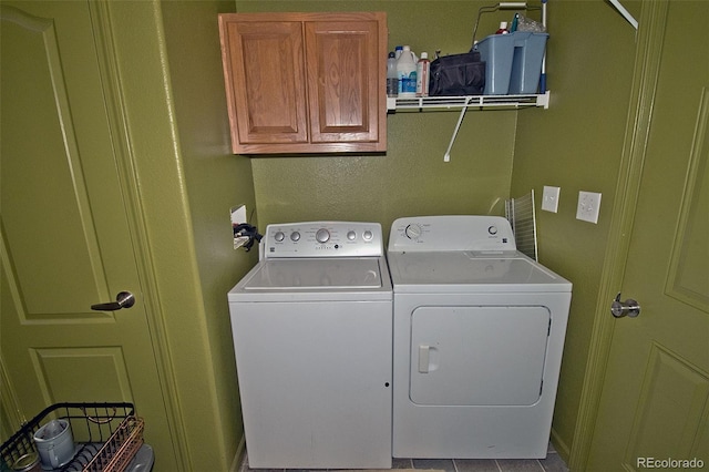 laundry area featuring separate washer and dryer, cabinets, and light tile patterned flooring