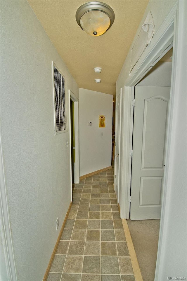 hallway featuring a textured ceiling