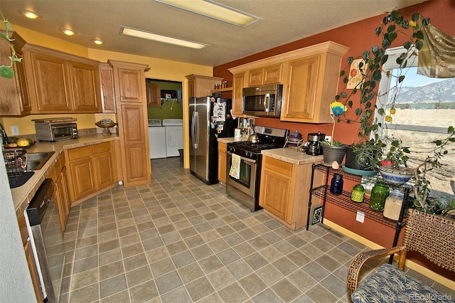 kitchen with sink, washer and dryer, and stainless steel appliances