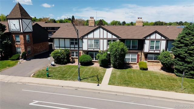 3825 S Monaco Pkwy Unit 111, Denver, CO 80237 - tudor house featuring a front yard and brick siding