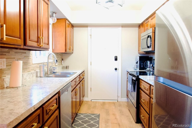 3825 S Monaco Pkwy Unit 111, Denver, CO 80237 - kitchen featuring stainless steel appliances, a sink, light wood-style flooring, and light countertops